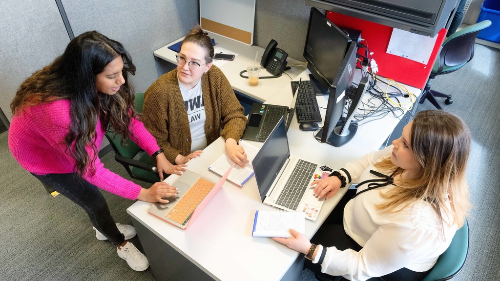 Students gathered at a desk in the JGRJ Office.