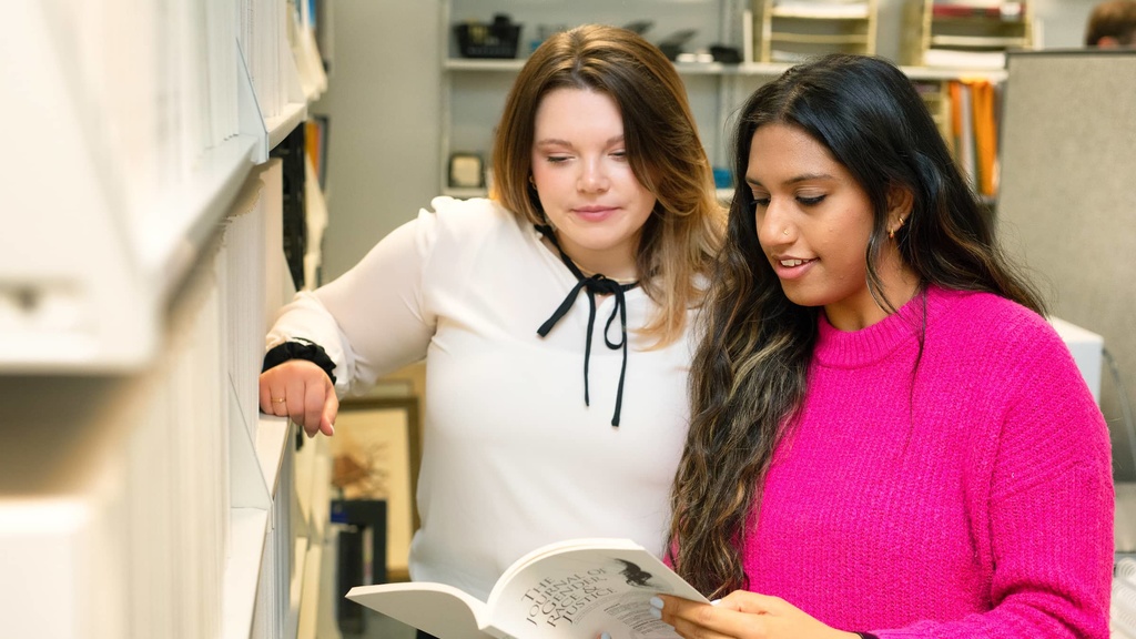 Sidney Holler and Maya Sanaba review journals in the JGRJ office.